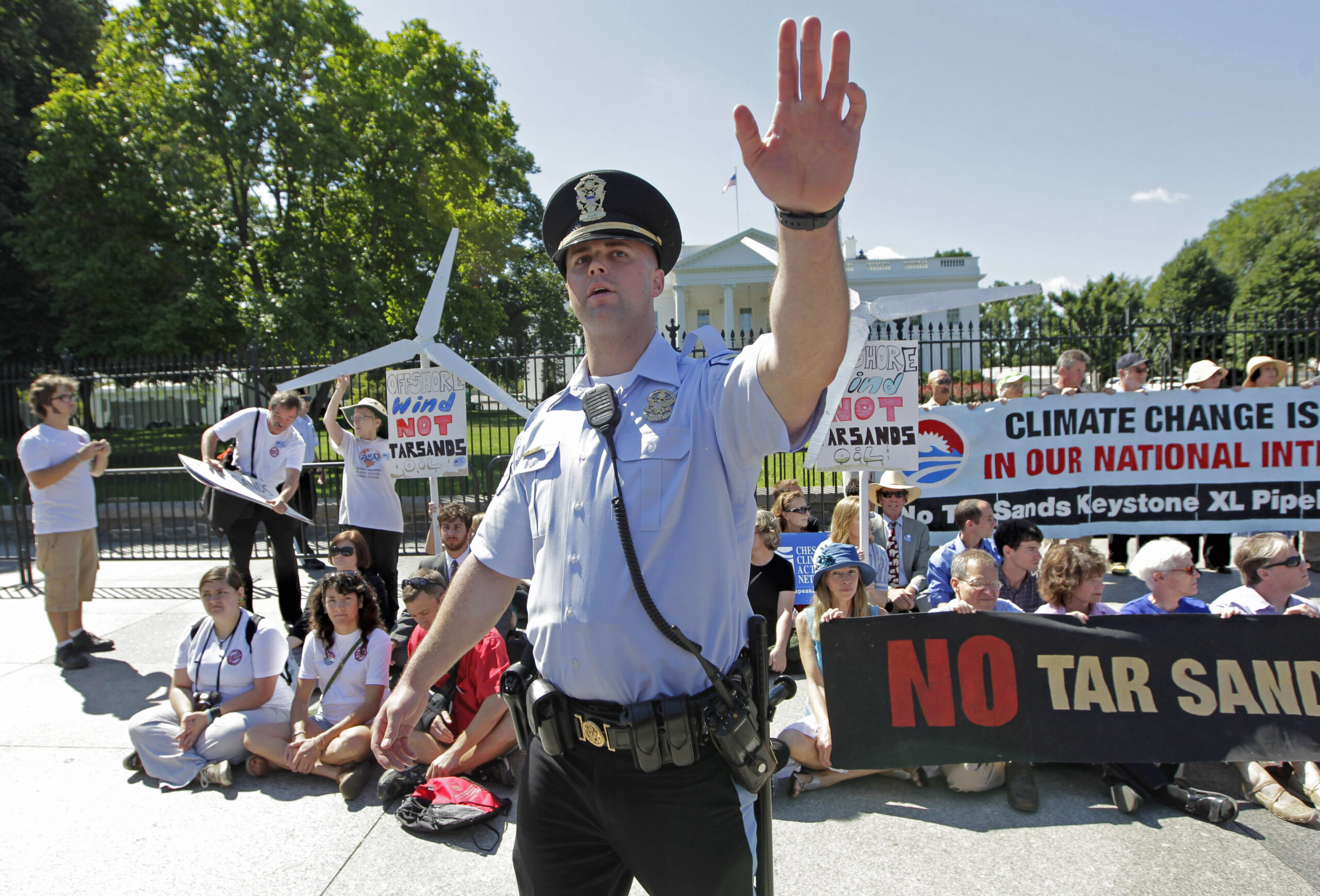 A police officer in front of activists protesting tar sands pipelines in front of the White House
